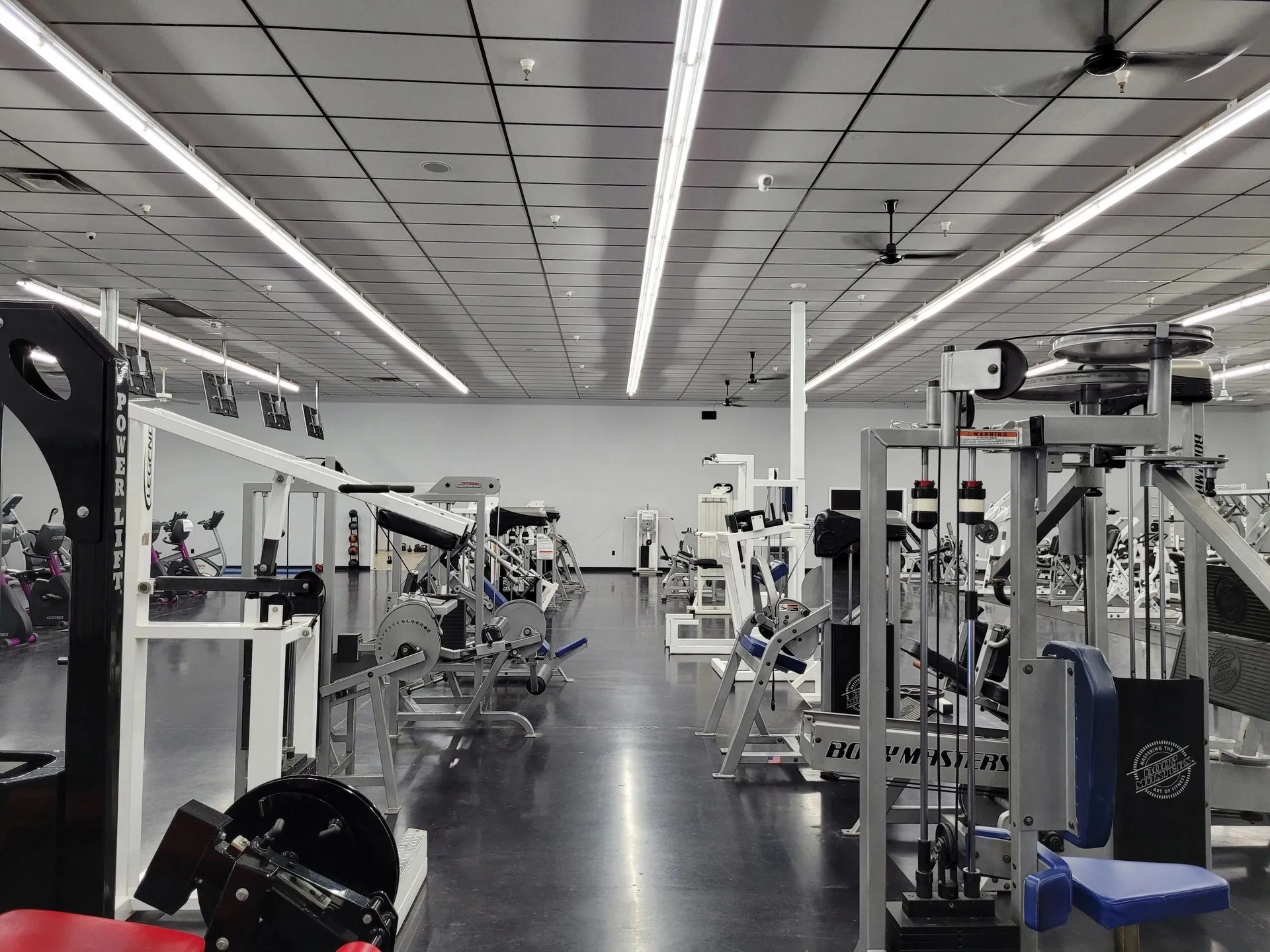 A wide view of the gym floor filled with strength and resistance machines